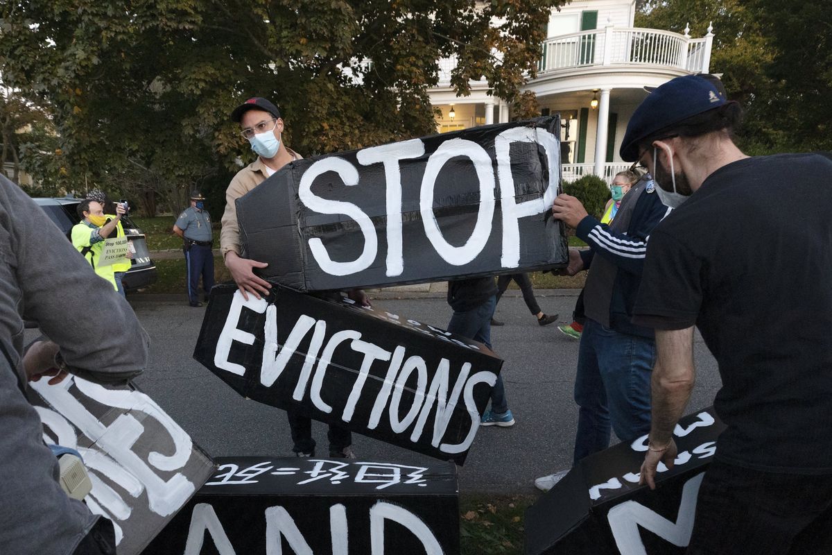 FILE - In this Oct. 14, 2020, file photo, housing activists erect a sign in front of Massachusetts Gov. Charlie Baker