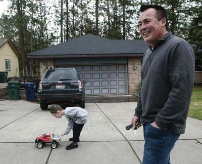 Four-year-old Matthew Heinen plays with a toy truck Thursday as his dad Eddie is interviewed in front of his home in Coeur d’Alene. (Kathy Plonka / The Spokesman-Review)