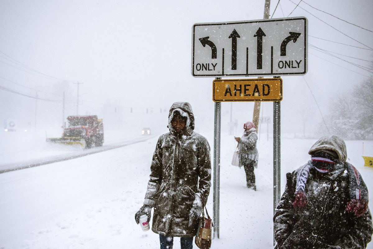 Charville Smith, left, Judy Simmons, center, and Cheryl Rosa stand at a Silver Lane bus stop waiting for their ride home after receiving a phone call from their employer, Cabela’s, that it was closing due a snowstorm Thursday, Feb. 9, 2017, in East Hartford, Conn. (Mark Mirko / Associated Press)