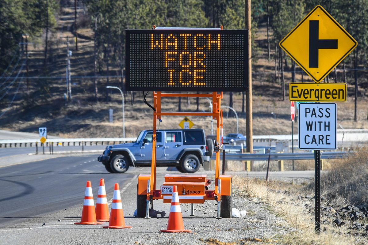 Vehicles approaching from the west on Bigelow Gultch Road are warned of water from a natural spring leaking through the asphalt near the Bigelow Gulch-Forker Rd. interchange, Wednesday, Feb. 10, 2021, leading to ice on the road and dangerous conditions.  (Dan Pelle/THESPOKESMAN-REVIEW)