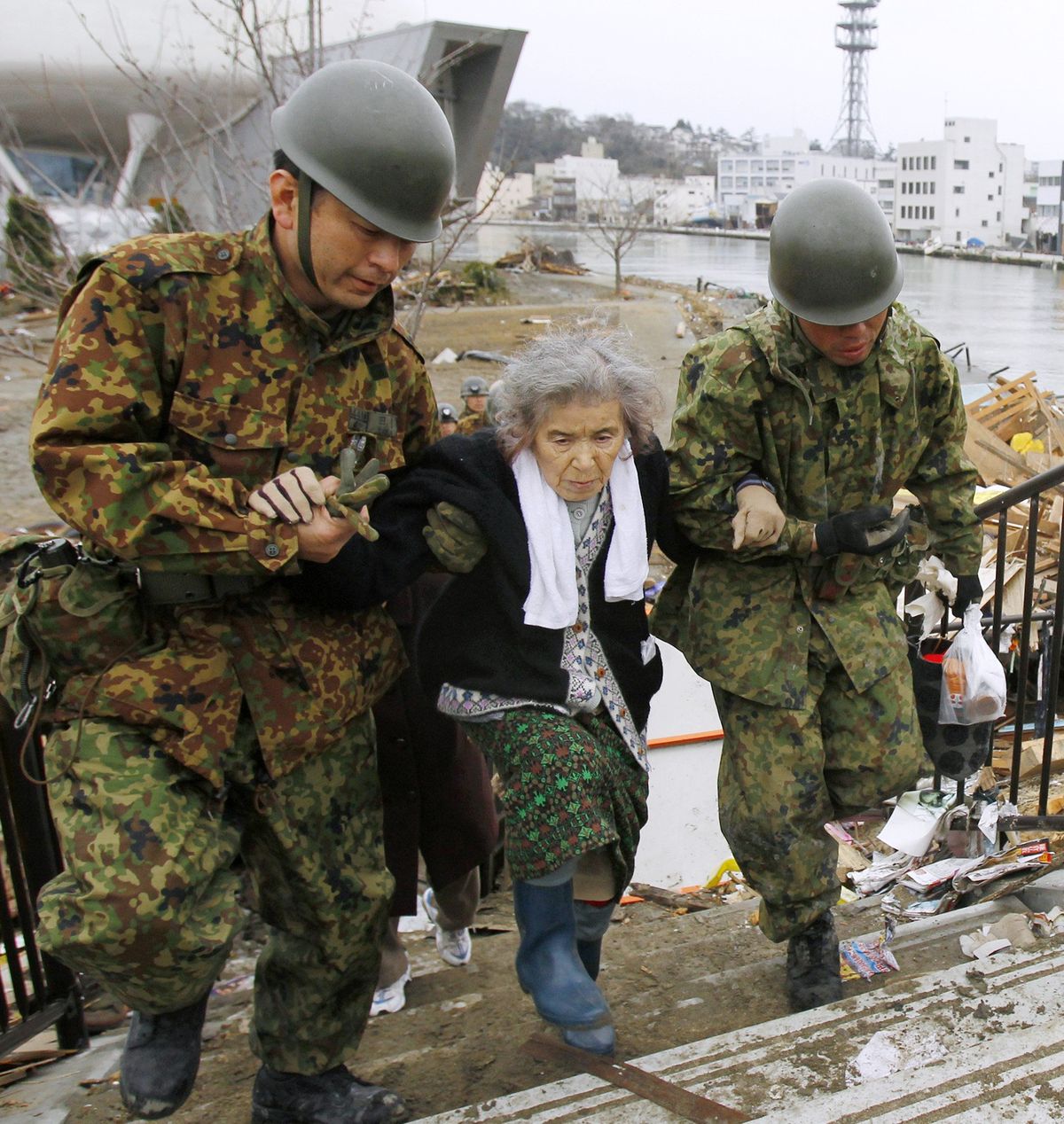 Fujiko Chiba, who was stranded in an isolated evacuation center for five days, is rescued by Japan Ground Self-Defense Force members in Ishinomaki, Miyagi Prefecture northern Japan today. (AP Photo/Kyodo News)