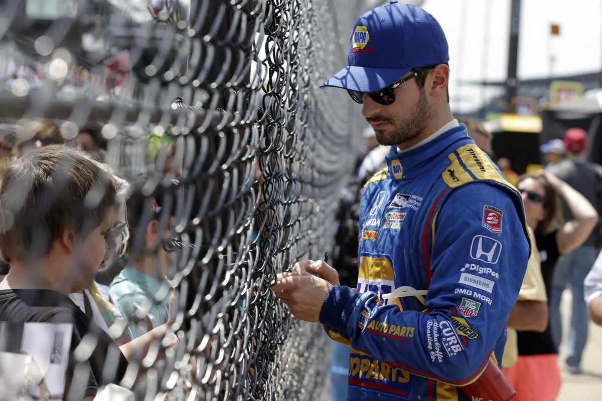 Alexander Rossi signs autographs through the fence in the pit area during a practice session for the Indianapolis 500 IndyCar auto race at Indianapolis Motor Speedway, Wednesday, May 17, 2017, in Indianapolis. (Michael Conroy / Associated Press)