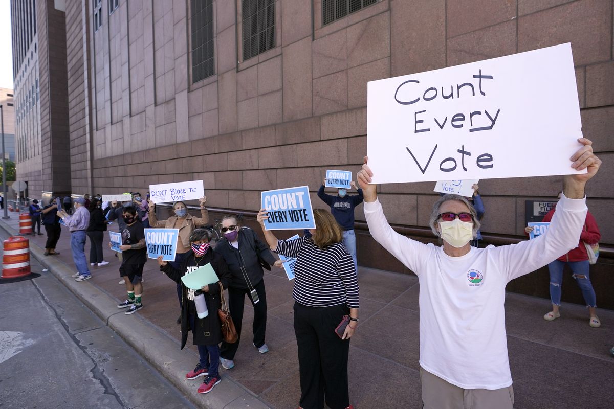 Demonstrators stand across the street from the federal courthouse in Houston, Monday, Nov. 2, 2020, before a hearing in federal court involving drive-thru ballots cast in Harris County. The lawsuit was brought by conservative Texas activists, who have railed against expanded voting access in Harris County, in an effort to invalidate nearly 127,000 votes in Houston because the ballots were cast at drive-thru polling centers established during the pandemic.  (David J. Phillip)