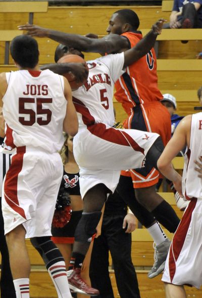 EWU’s Justin Crosgile grabs the rebound, but Cal State Fullerton’s Marquis Horne makes him pay. The Eagles prevailed 79-75 at Reese Court on Friday. See story, C7. (Jesse Tinsley)