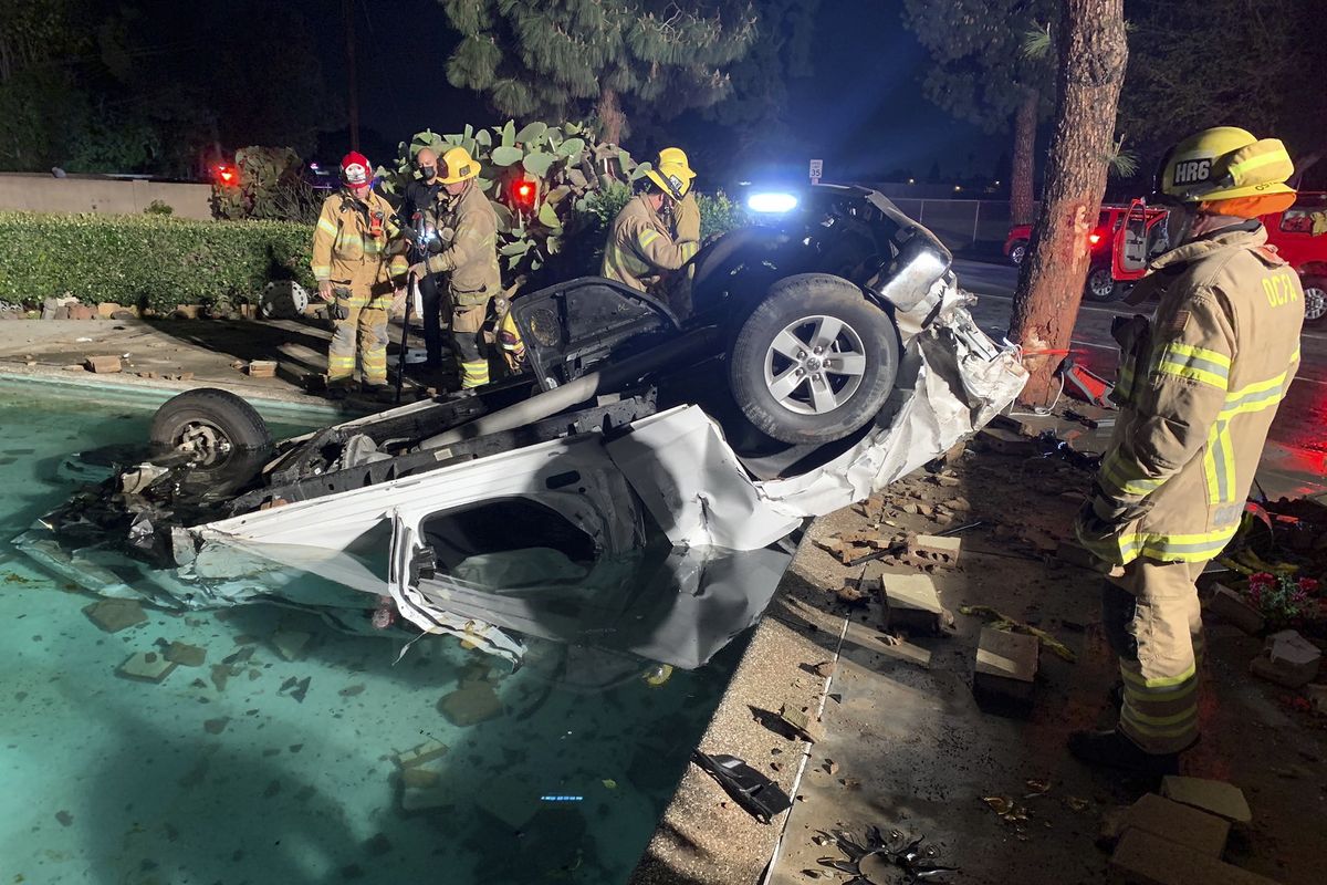 Orange County Fire Authority firefighters and paramedics respond to a two-vehicle collision after a vehicle sheared a hydrant and smashed through a wall, landing upside down in a pool in Garden Grove, Calif., on Friday, March 12, 2021. A new study by Washington State University has discovered reasons why night-shift workers, including firefighters and paramedics, are at higher risk for developing cancer. (Orange County Fire Authority/AP)