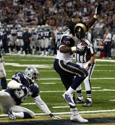 St. Louis running back Steven Jackson, right, slips past Dallas’ Roy L. Williams for the first of his three touchdown runs. Asssociated Press (Asssociated Press / The Spokesman-Review)