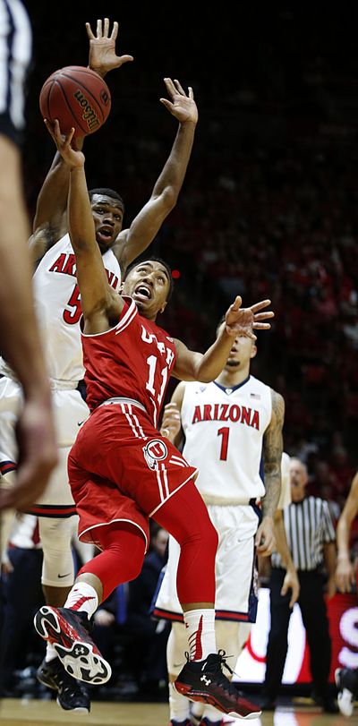 Utah guard Brandon Taylor (center) shoots past Arizona guard Kadeem Allen (left). Taylor scored 19 points during the Utes’ 70-64 win Saturday in Salt Lake City. (Associated Press)