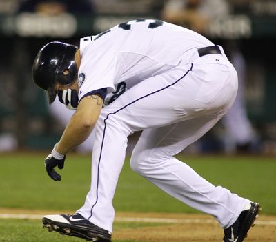 Seattle Mariners' Casper Wells reacts to being hit in the face by a pitch from Toronto Blue Jays pitcher Brandon Morrow, in the sixth inning Wednesday night's game in Seattle. Wells was taken out of the game. (Ted Warren / Associated Press)