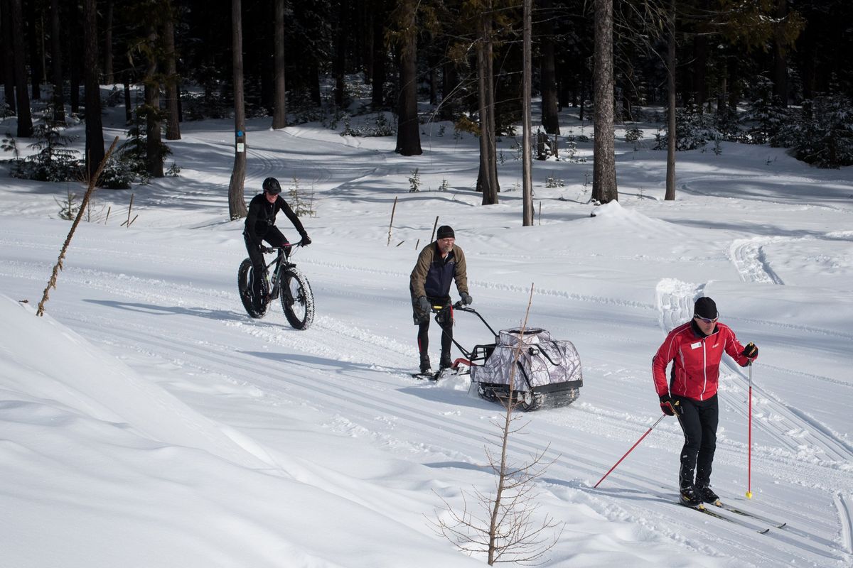 Frank Benish, center, demonstrates a small snow groomer used to create fat bike trails at 49 Degrees North. This year, Benish groomed 20 miles of trail at Riverside State Park before the snow melted.  (Eli Francovich)