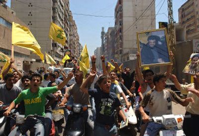 
Lebanese youths in Beirut wave Hezbollah flags as they celebrate the  capture of two Israeli soldiers. 
 (Associated Press / The Spokesman-Review)