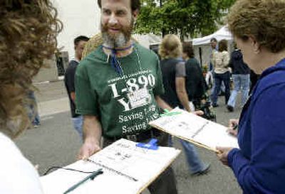 Volunteer Charles Creso seeks signatures for an anti-smoking plan from Karla Nordstrom, left, and her mother, Rosemary Nordstrom, right, in Tacoma.
(Associated Press / The Spokesman-Review)