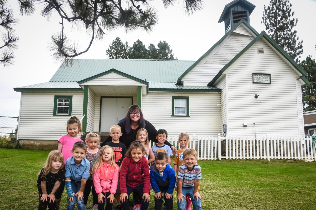 Orchard Prairie School kindergarten students, front row, from left: Clementine Ford, Henry Denison, Maple Utley, Kateri McCall, Xander Linares, and Johannin Lathrum. Back row: Izabel Clark, Edan Anderson, August Czapla, teacher Kirsten Schierman, Faith Amestoy, Tate Cruz and Aurora Cushman. The class gathers outside the original school, the right half, built in 1894. An addition was added in 1904, the left side. (Dan Pelle / The Spokesman-Review)