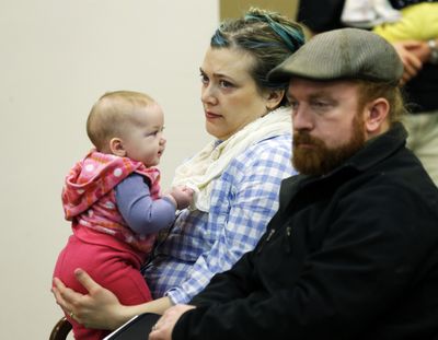 Grant Keller and his wife, Charis, of Spokane, sit with their daughter Aille, 5 months, as they wait to testify Tuesday against House Bill 2009 during a hearing at the Capitol in Olympia. (Associated Press)