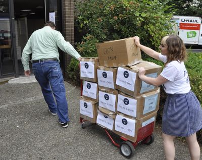 Supporters of I-1464, an initiative that would change some of the state’s campaign finance laws and increase government transparency, wheel cartons of signed petitions into the state elections office in Olympia shortly before the deadline on July 8, 2016. (Jim Camden / The Spokesman-Review)