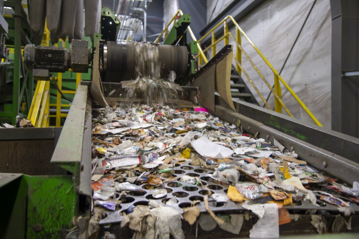 Small materials, mostly paper and glass, that haven’t been removed by other processes bounce down a shaker table as a last ditch way to separate them before they end up in the garbage. Comingled recycling products go through an elaborate system of automated machines and human pickers to separate them into their respective bins.  (Jesse Tinsley/The Spokesman-Review)