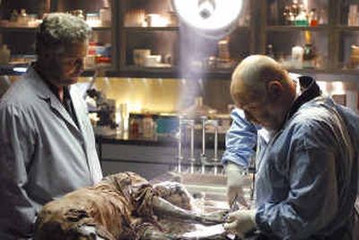 
Robert David Hall, right, performs an autopsy on a mummified corpse as William Petersen looks on in a scene from CBS' 
