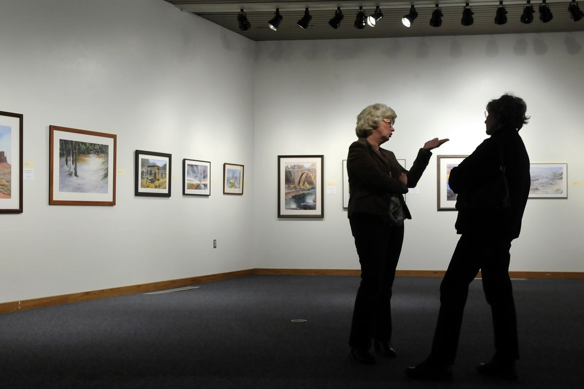 Bonnie Whinnen, left, and Bobbie Wieber talk watercolors while visiting the Spokane Watercolor Society exhibit at the Chase Gallery. (Dan Pelle)