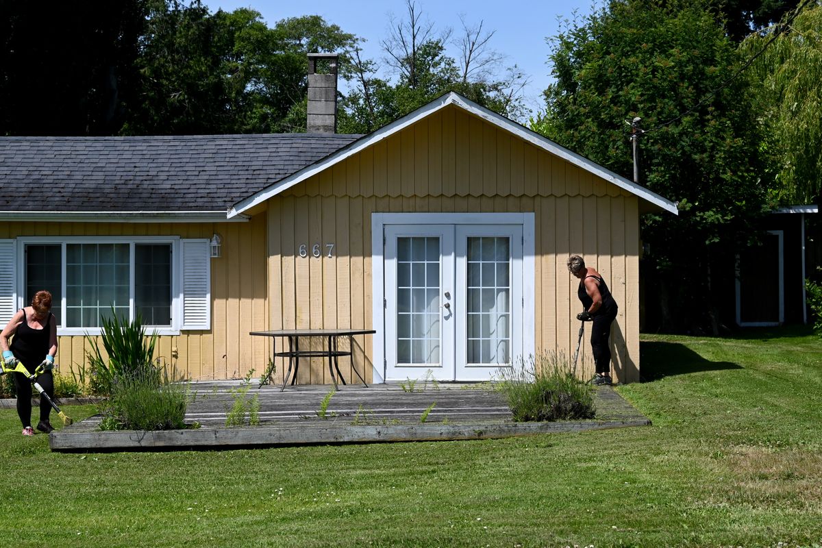 Diane Thomas, 72, left, and her sister Jeanette Meursing, 74, trim the lawn of an absent community neighbor Thursday in Point Roberts, Wash.  (Tyler Tjomsland/The Spokesman-Review)