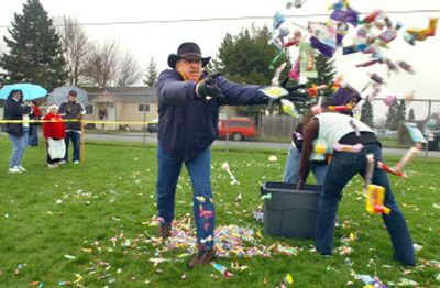 
Paul Guidry throws handfuls of candy to cover the ground before kids flood the area to pick it up Saturday at Borah Elementary in Coeur d'Alene.
 (Jesse Tinsley / The Spokesman-Review)