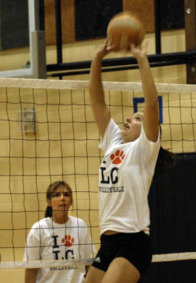 
Senior Laurie Yearout goes up for the ball as her mother and coach, Julie, watches during a practice at Lewis and Clark.
 (Liz Kishimoto / The Spokesman-Review)