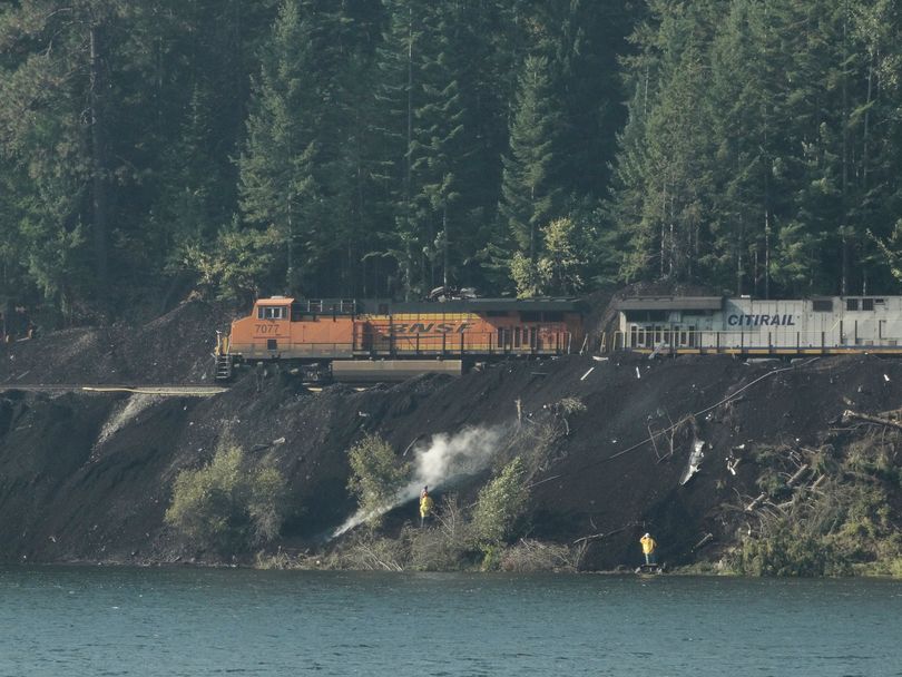 On Sept. 16, 2017, Montana Rail Link crews tend to smoldering coal that had spilled along the Clark Fork River during a train derailment in mid-August. The photo was taken in Montana from SR 200 east of the Idaho state line at Milepost 8.  (Sandy Compton)