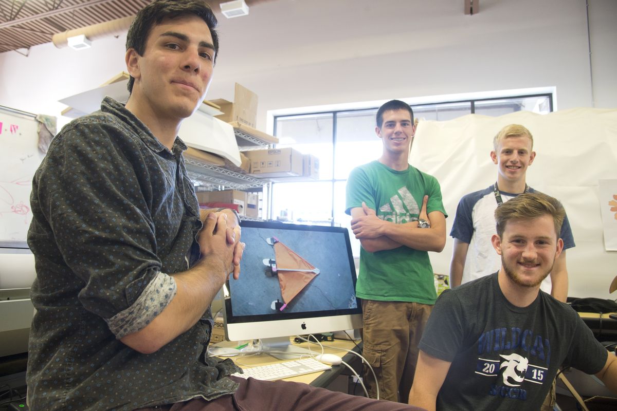 From left, Max Delsid, Jared Timme, Connor Hawkes, standing, and Liam Maddox of Riverpoint Academy stand next to a computer showing one of their early versions of a rocket-launched remote-controlled airplane at Riverpoint on Monday. (Jesse Tinsley)