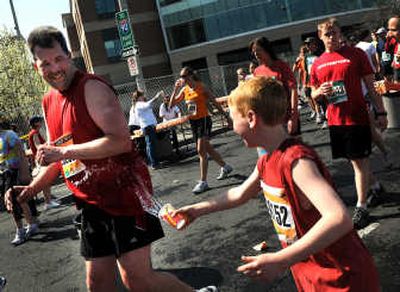 
Brenden Millikan, 10, splashes his father, Don, after the Spokane residents finished the race together. 
 (Rajah Bose / The Spokesman-Review)