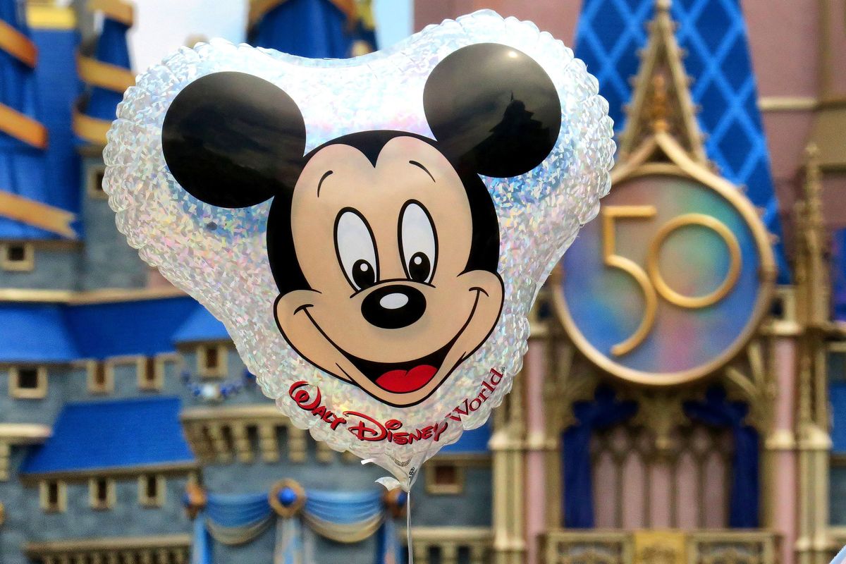 A Mickey Mouse balloon floats in front of Cinderella Castle and the 50th anniversary crest in the Magic Kingdom at Walt Disney World, in Lake Buena Vista, Florida, on July 23, 2021. (Joe Burbank/Orlando Sentinel/TNS)