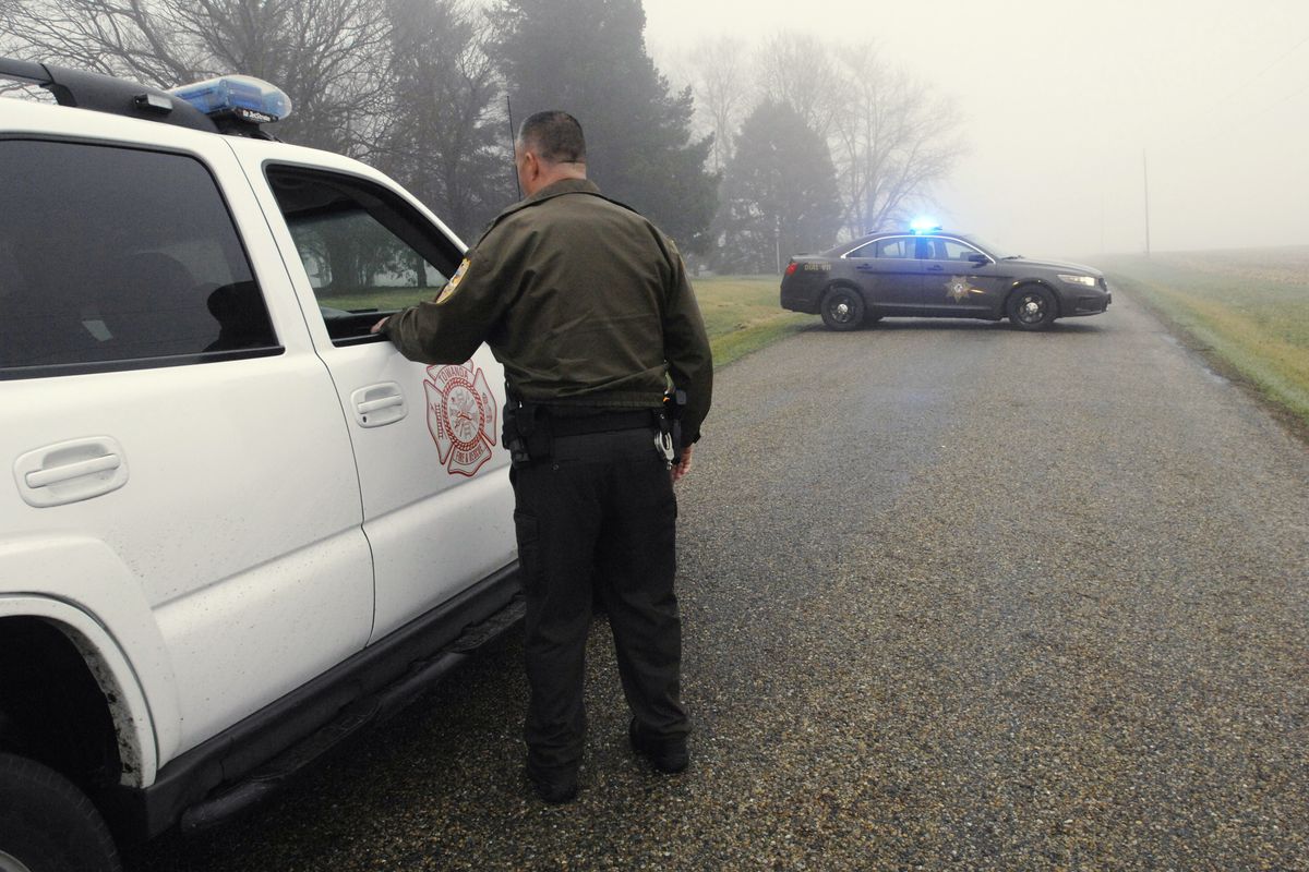 A McLean County sheriff's deputy mans a roadblock at the scene near Bloomington, Ill., where a small plane crashed with at least five on board early Tuesday, April 7, 2015. The Federal Aviation Administration says the Cessna 414 crashed just short of the Bloomington airport after midnight Tuesday while returning from the NCAA basketball championship in Indianapolis. (David Proeber / The Pantagraph)