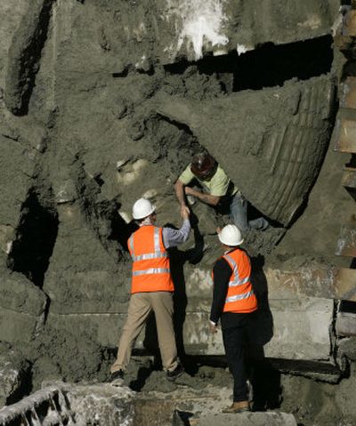 
Tunnel boring machine operator Pat Gould crawls through the teeth of the machine Tuesday with help from Sound Transit board members.
 (The Spokesman-Review)
