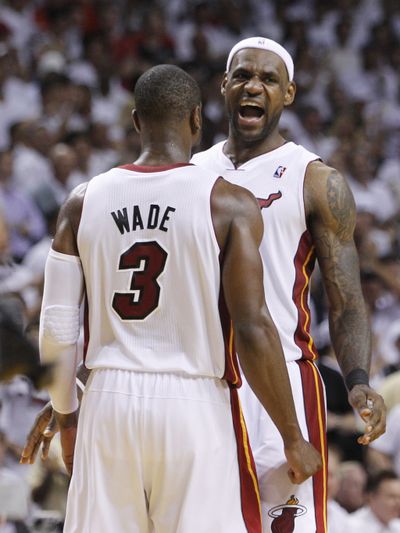 Miami Heat’s LeBron James and Dwyane Wade (3) celebrate their overtime win over the Chicago Bulls on Tuesday night. (Associated Press)