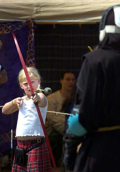 
Elizabeth Morse fires an arrow at an English knight at The Adrian Empire booth at last year's  Spokane Highland Games. 
 (FILE / The Spokesman-Review)
