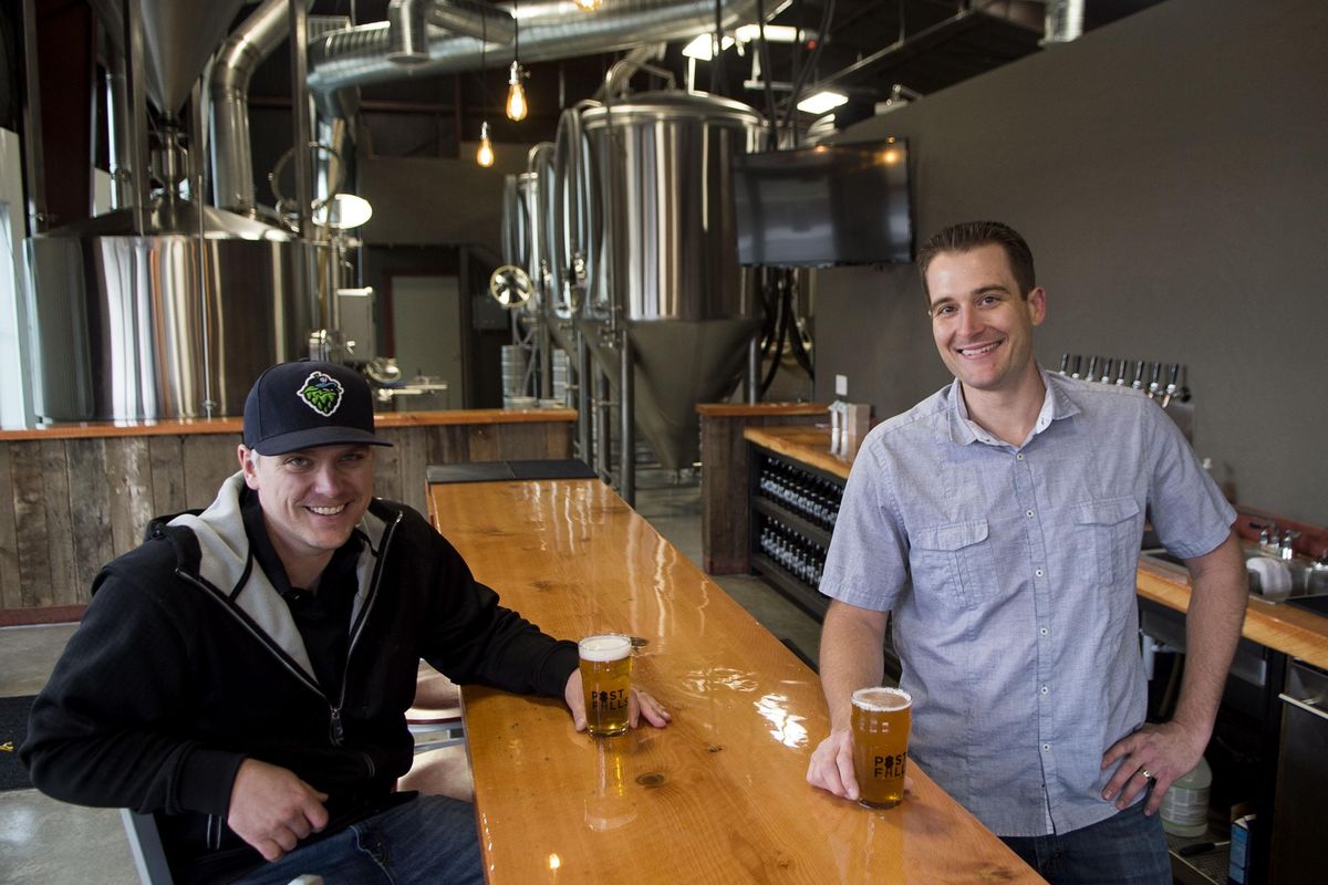Dan Stokes, left, and Alex Sylvain, owners of Post Falls Brewing, talk about their new business in Post Falls on Thursday, April 14, 2016. (Kathy Plonka / The Spokesman-Review)