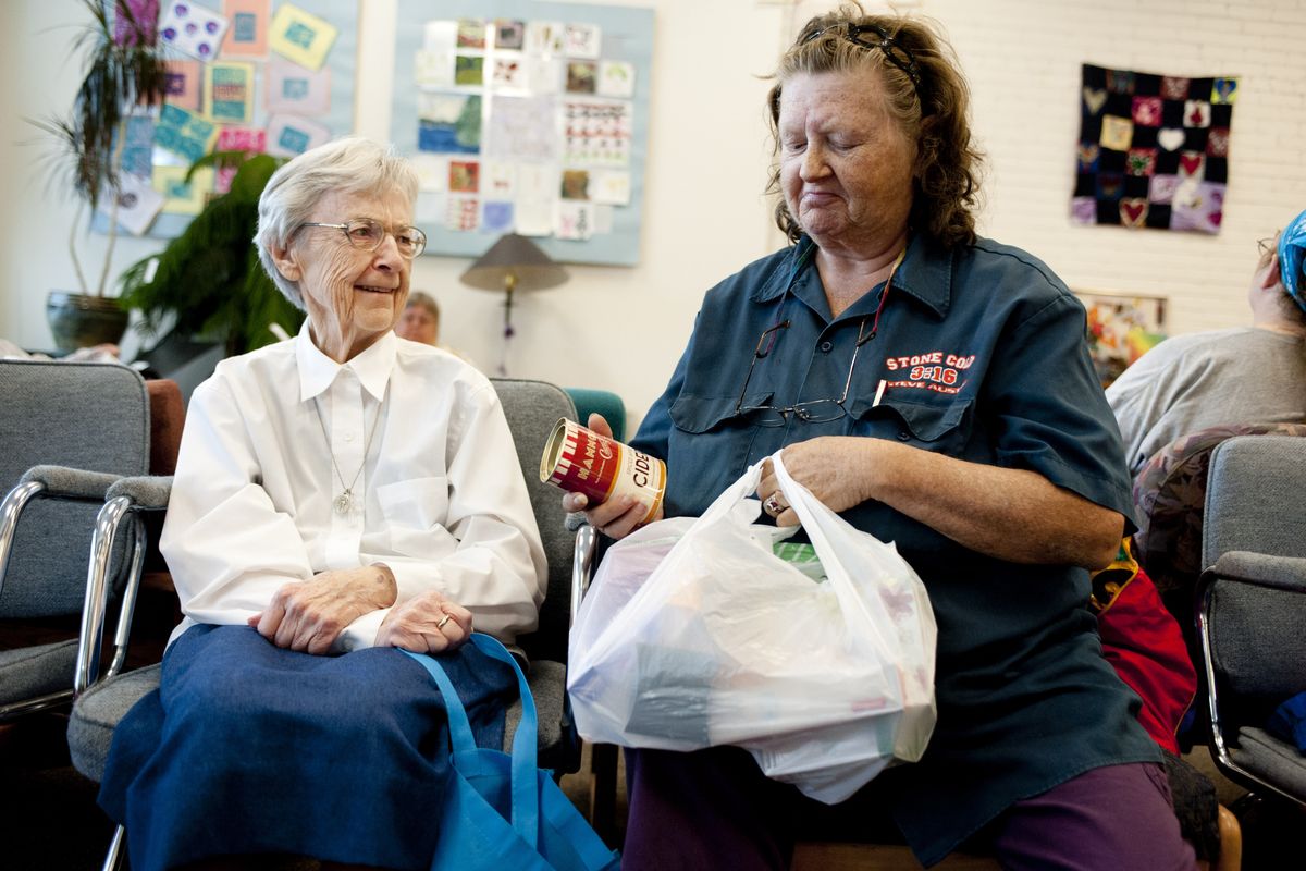 Holy Names Sister Mary Bridget Ward, left, drops off food and supplies to Women’s Hearth volunteer Gloria Bost on Sept. 6. (Tyler Tjomsland)