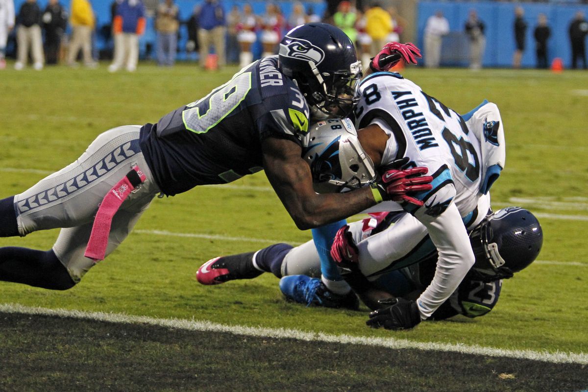 Seattle’s Brandon Browner, left, and Marcus Trufant keep Carolina’s Louis Murphy out of the end zone late in the fourth quarter. (Associated Press)