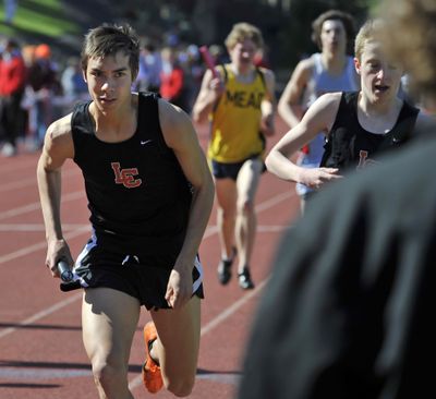 Lewis and Clark’s Kenji Bierig, left, takes the baton for the final leg of the 4x1,600-meter relay that LC won. (Dan Pelle)
