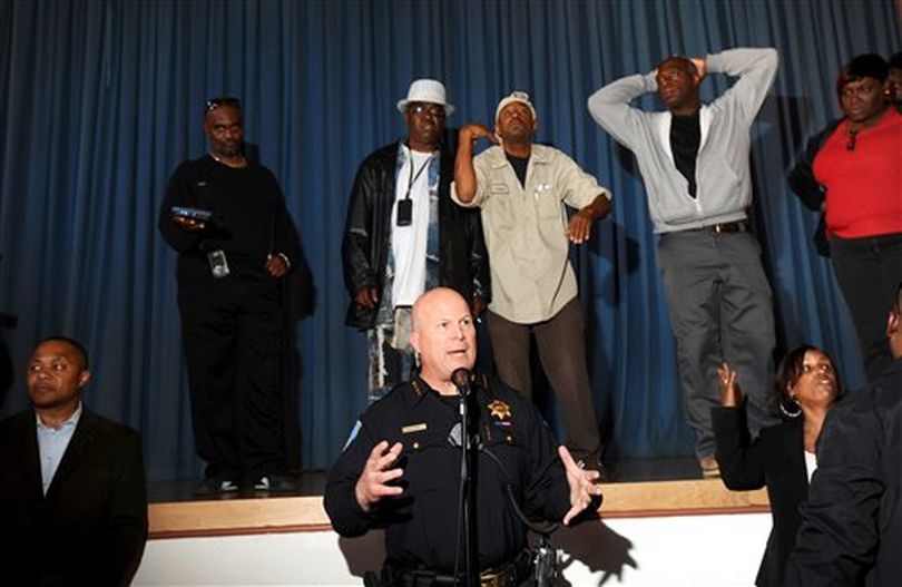 In this photo from Wednesday, July 20, 2011, San Francisco Police Chief Greg Suhr, bottom, addresses Bayview residents upset about the police shooting of Kenneth Wade Harding in San Francisco. About 300 people gathered for the meeting which ended early following outbursts from some attendees. New developments into the shooting death of 19-year-old Washington state parolee Kenneth Harding has evolved into a perplexing mystery that may do little to quell tensions between the police and the community that goes back decades. Police said Thursday that they believe Harding fatally shot himself in the neck and the bullet went to his head, a stunning twist after police thought that officers killed him after he allegedly opened fire first. (AP Photo/San Francisco Chronicle, Noah Berger)  ((AP Photo/San Francisco Chronicle, Noah Berger) )