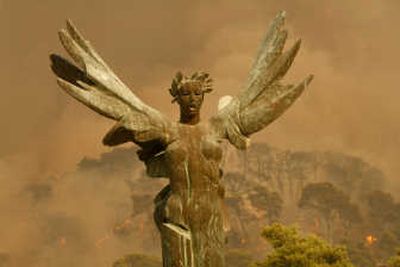 
The winged statue of victory stands in front of smoke from fires in the village of Ancient Olympia, near the birthplace of the Olympic Games, in southwestern Greece on Sunday.Associated Press
 (Associated Press / The Spokesman-Review)