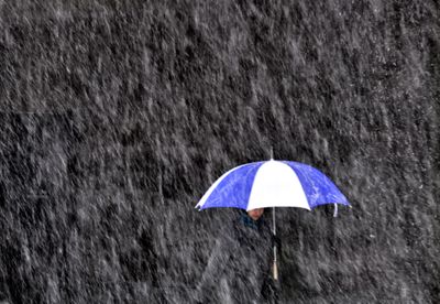A pedestrian makes her way through heavy snow on Post Street in downtown Spokane on Wednesday afternoon.  (Colin Mulvany / The Spokesman-Review)