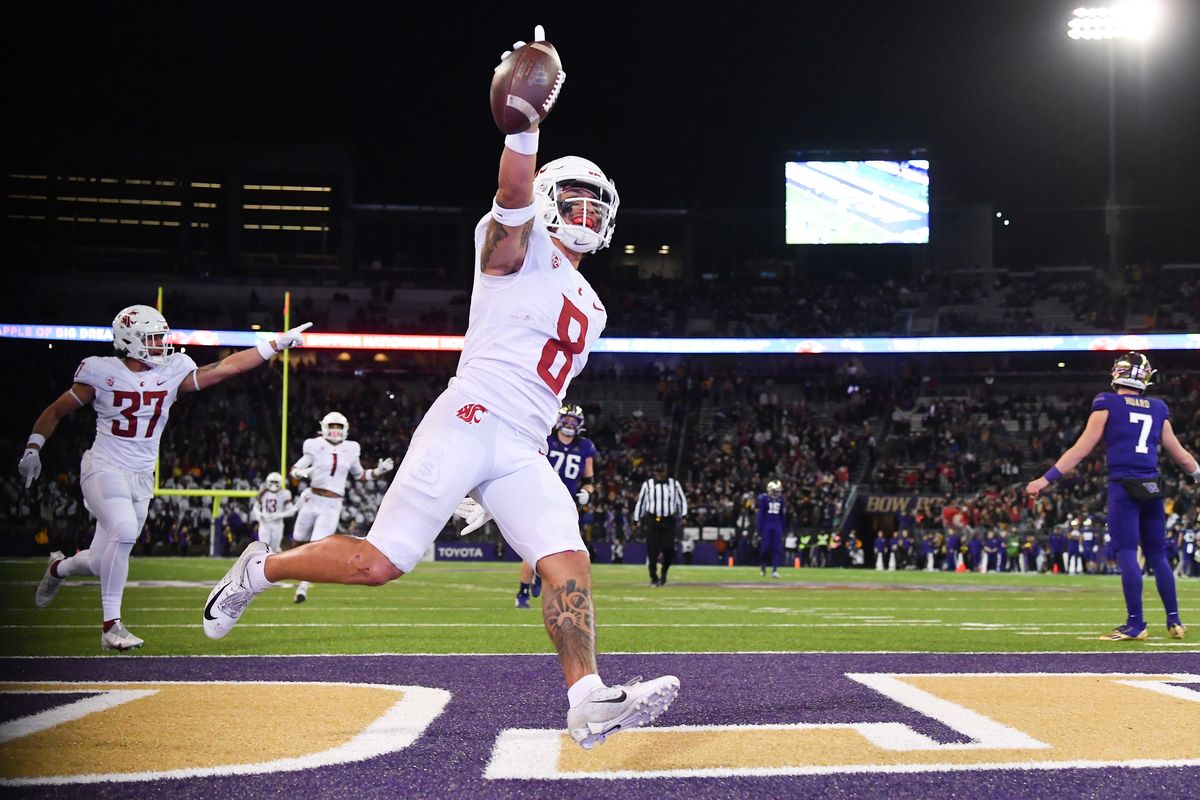 Washington State Cougars defensive back Armani Marsh (8) runs the ball into the endzone for a touchdown after picking off Washington Huskies freshman quarterback Sam Huard (7) as Huard, right, reacts in the direction of the UW bench during the second half of a college football game on Friday, Nov 26, 2021, at Husky Stadium in Seattle, Wash. WSU won the game 40-13  (Tyler Tjomsland/The Spokesman-Review)