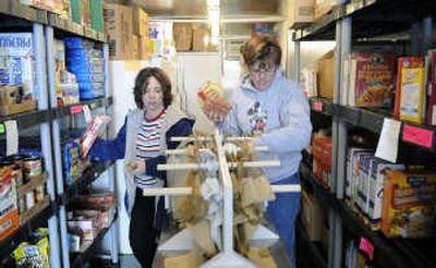 
Lisa Vorhies, left, and Kerri York fill plastic shopping bags with food items at the Serve Spokane Food Pantry located at the Lyons Theaters in North Spokane. 
 (Dan Pelle / The Spokesman-Review)