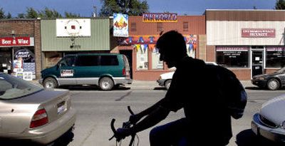 
A bicyclist rides down Fourth Street  in midtown Coeur d'Alene on Tuesday. Neighbors are brainstorming ways to make the strip a more attractive place to live and shop. 
 (Kathy Plonka / The Spokesman-Review)