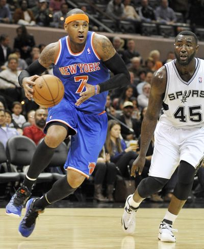 The Knicks’ Carmelo Anthony drives around the Spurs’ DeJuan Blair in a victory that improved New York’s record to 6-0. (Associated Press)