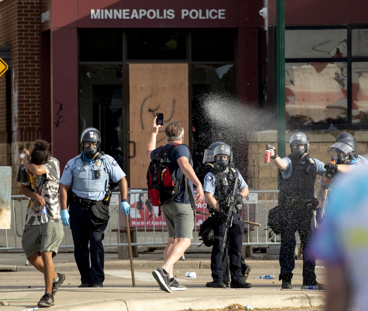 FILE - In this May 27, 2020, file photo, Police spray protesters as demonstrations continue at the Minneapolis 3rd Police Precinct in Minneapolis. More than 150 Minneapolis police officers have started the process of filing for disability claims since the death of George Floyd and the ensuing unrest in the city, with the majority citing post-traumatic stress disorder as the reason for their planned departure, according to an attorney representing the officers.  (Carlos Gonzalez)