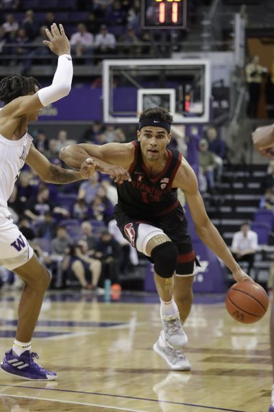 Stanford's Oscar da Silva, right, tries to get past Washington's RaeQuan Battle during the first half of an NCAA college basketball game Thursday, Feb. 20, 2020, in Seattle. (Elaine Thompson / AP)