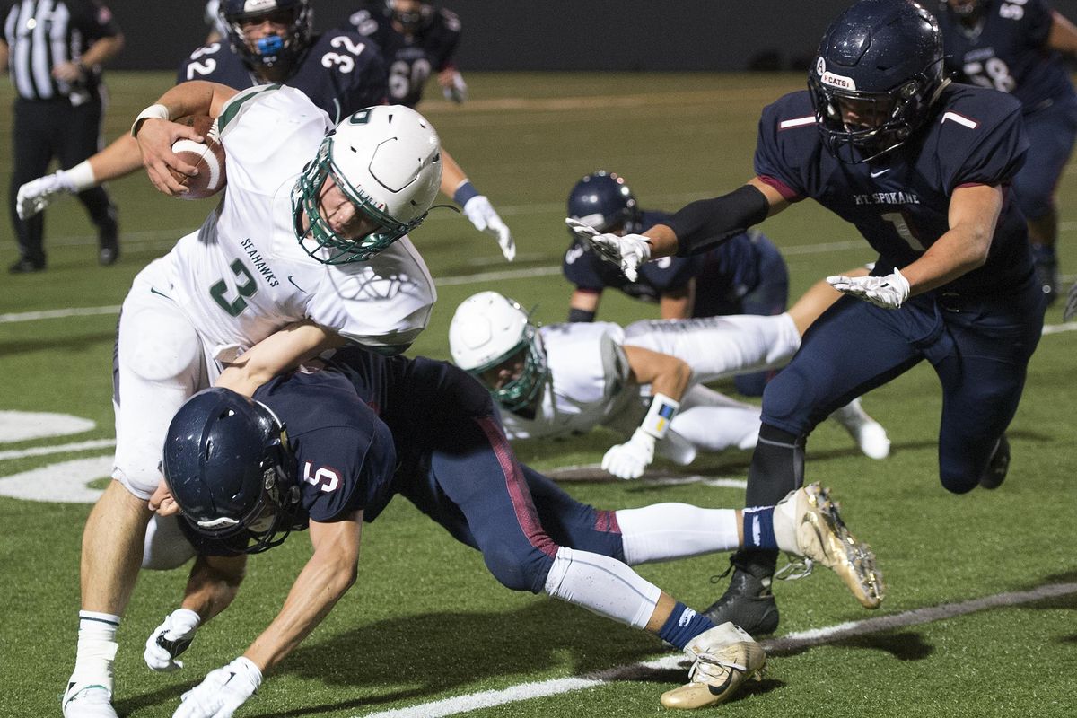 Peninsula running back Cameron Lewis (3) is tackled by Mt. Spokane’s Caleb Countryman in the first half of a GSL high school football game Friday night at Joe Albi Stadium. (Colin Mulvany / The Spokesman-Review)