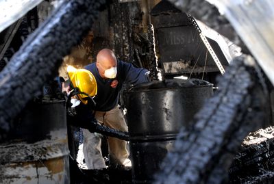 Investigators Jimmy Bowen, left, and Jason Reser examine fire damage at  a warehouse at  Napa Street and Grace Avenue in north Spokane on Wednesday.  (KATE CLARK / The Spokesman-Review)