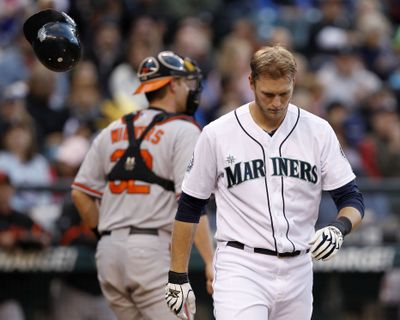 Mariners’ Michael Saunders walks past his bouncing helmet after he slammed it down after striking out in fifth inning. (Associated Press)