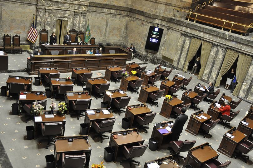 OLYMPIA -- The Washington Senate opens the special session on Monday morning with a mostly empty chamber, with Sens. Joe Fain (standing, at right), David Frockt and Sharon Nelson at their desks and Lt. Gov. Cyrus Habib and the Senate administrative staff at the rostrum. Sen. Bob Hasegawa was also in the back of the chamber. (Jim Camden/The Spokesman-Review)