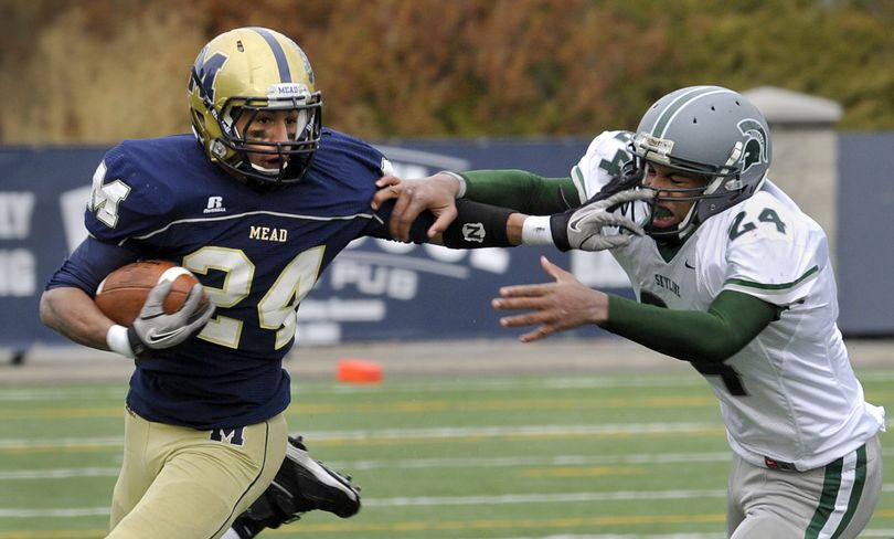 Mead’s Davian Barlow, left, fights off Skyline’s Devin Benford on a first-half run Saturday at Albi Stadium. (Dan Pelle)